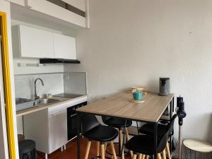 a small kitchen with a wooden table and chairs at Maisonnette de Plage in Saint-Hilaire-de-Riez