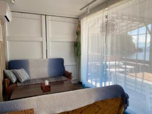 a small room with a couch and a window at プチリゾート・ひじきwest in Hijiki