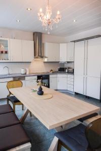 a kitchen with a wooden table and white cabinets at Bryza Homes - Villa Linde - Parkplatz - Ahlbeck - Patio in Ahlbeck +111 photos