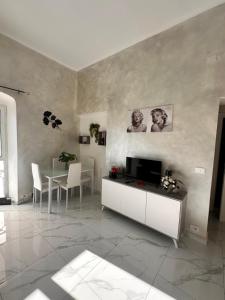 a living room with a television and a table with chairs at Chez Grenuel in Sanremo