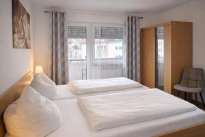 zwei Betten in einem Hotelzimmer mit Fenster in der Unterkunft Hotel Discovery in Stuttgart