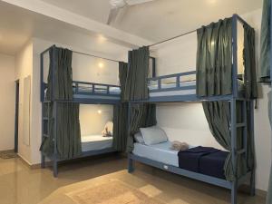 a room with two bunk beds in a room at Artjuna Cabanas - CoLiving Community in Anjuna in Anjuna