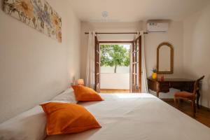 a bedroom with a bed with orange pillows and a desk at Domo de Iannas-House Live Express in Quartu Sant'Elena