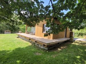 a log cabin with a deck in a yard at Hamerenne in Rochefort