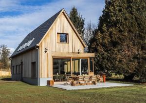 a large wooden barn with a table and chairs at Le Gîte du Haras in Falaën
