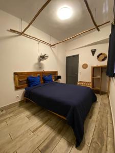 a bedroom with a large bed with blue pillows at Jiro Hôtel in Antananarivo