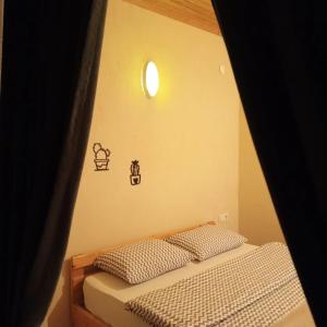 a bedroom with a bed with a light on the wall at Balcı Konukevi in Artvin