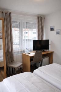 ein Schlafzimmer mit Schreibtisch, Computer und Bett in der Unterkunft Hotel Discovery in Stuttgart