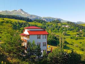 a house with a red roof on a hill at Balcı Konukevi in Artvin