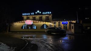 a car parked in front of a building at night at Three Star in Almaty