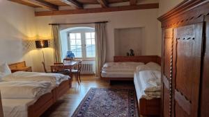 a bedroom with two beds and a dining room with a table at NRAR Hotel Hirschen in Beromünster