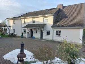 a large white house with a black roof at Ferienwohnung Bienwald mit Pool für 4 - 6 Personen mit 3 Schlafzimmern in Gröbitz