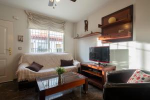 a living room with a couch and a tv at Casa modernista in La Zubia