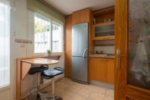 a kitchen with a refrigerator and a table and a stool at Casa modernista in La Zubia