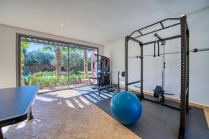 a room with a gym with a large window at Villa JUZYAN une parenthèse de bien-être et de convivialité in Marrakesh