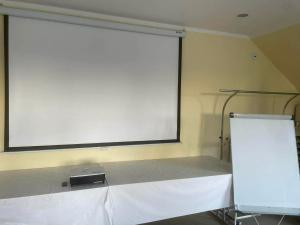 a large projection screen on the wall of a room at Pod Parkanami in Spiczyn