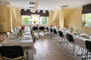 a large room with long tables and chairs at Pod Parkanami in Spiczyn