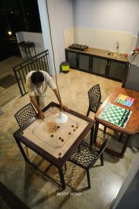 a man playing a game on a table at Vythiri Misty Wind Holiday Homes in Vythiri