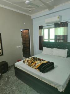 a bedroom with a bed with a black blanket on it at Royal Rudraksh Palace in Bābatpur