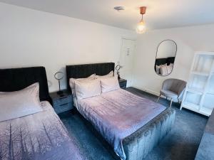 a bedroom with two beds and a mirror and a chair at Barber House, Hoyland with two allocated parking spaces in Hoyland Nether