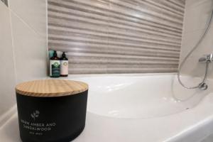 a bathroom with a bath tub with a stool next to it at Sphynx Apartment Pipera in Voluntari +8 photos