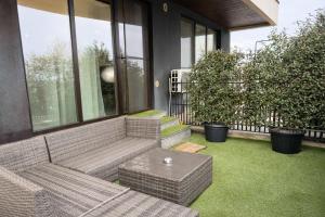 a patio with a couch and a table on the grass at Sphynx Apartment Pipera in Voluntari