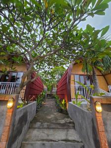 a staircase leading to a house with a tree at Eco Moringa Garden in Banyuwedang
