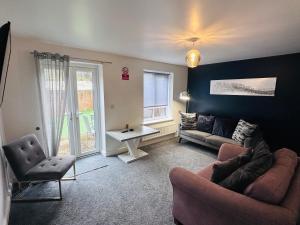 a living room with a couch and a table at Barber House, Hoyland with two allocated parking spaces in Hoyland Nether