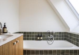 a bathroom with a bath tub in a attic at Le Gîte du Haras in Falaën +51 photos