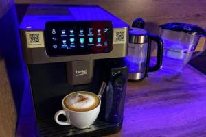 a coffee maker with a cup of coffee on a table at Apartament Corner Cappuccino z wanną z hydromasażem w centrum Tomaszowa! Parliamo anche Italiano! in Tomaszów Mazowiecki +32 photos