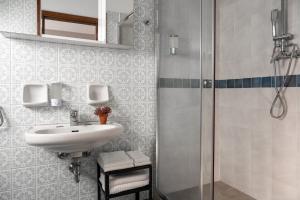a bathroom with a sink and a shower at MEMÒ Cesenatico in Cesenatico +35 photos