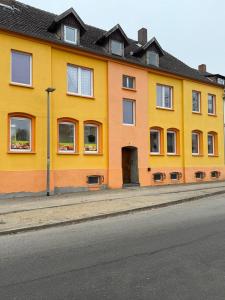 a yellow building on the side of a street at Frisch sanierte Ferienwohnung in Grabow in Grabow
