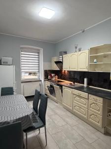 a kitchen with white cabinets and a table and chairs at Frisch sanierte Ferienwohnung in Grabow in Grabow