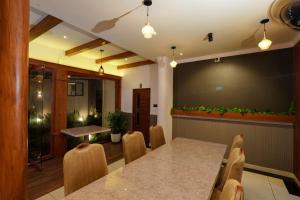 a dining room with a table and chairs and a large screen at Adonna Beach Resort in Alleppey