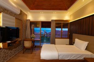 a bedroom with a bed and a desk and a television at Adonna Beach Resort in Alleppey