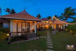 a house with a pathway in front of it at Adonna Beach Resort in Alleppey