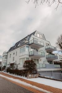 a white building with balconies on the side of it at Ferienwohnung Wirbelwind in Scharbeutz