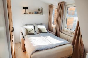 a small bedroom with a bed and a window at Ferienwohnung Wirbelwind in Scharbeutz