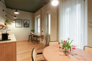 a kitchen and dining room with a table with flowers on it at Cà Bèla - Venini in Milan
