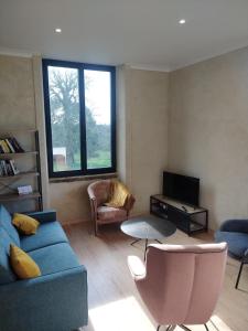 a living room with a blue couch and a tv at La Tour de Vesly in Belval