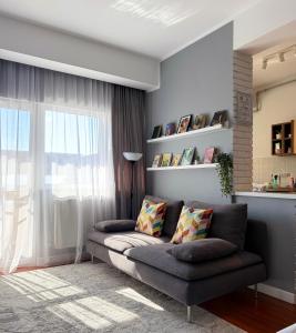 a living room with a couch and a window at Divine Studio Fermei 62 in Popeşti-Leordeni
