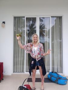 a woman standing in front of a window holding a banana at Exin River Breeze Transit Hotel - Katunayake in Dandugama