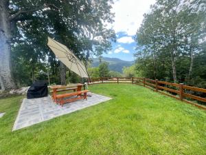 a picnic table with an umbrella in the grass at Apartma Lozar in Ajdovščina