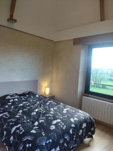 a bedroom with a bed and a large window at La Tour de Vesly in Belval