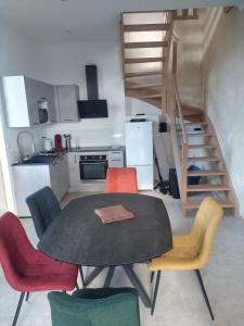a kitchen with a table and chairs and a stair at La Tour de Vesly in Belval