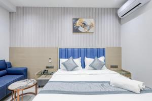 ein Schlafzimmer mit einem großen Bett mit blauem Kopfteil in der Unterkunft Hotel Lacasa in Sātej