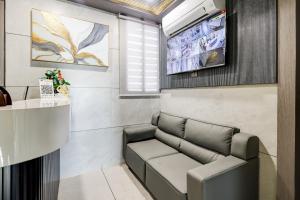 Ein Wartezimmer mit Sofa und Fernseher in der Unterkunft Hotel Lacasa in Sātej