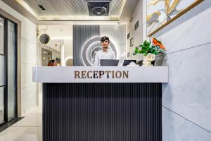 ein Empfangstresen in einem Gebäude mit einem Mann dahinter in der Unterkunft Hotel Lacasa in Sātej