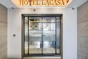eine Tür zu einer Hotellobby mit einem Hotel-Lazarus-Schild in der Unterkunft Hotel Lacasa in Sātej + 27 Fotos