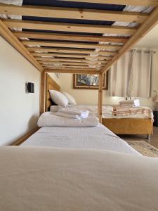 two beds in a bedroom with a wooden ceiling at פסטרנק אירוח יער אודם in Odem